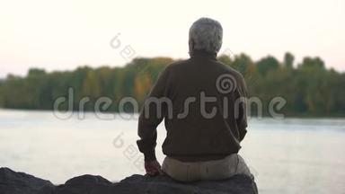 一个悲伤的人坐在河畔，想着他生命中的时刻，<strong>怀念</strong>